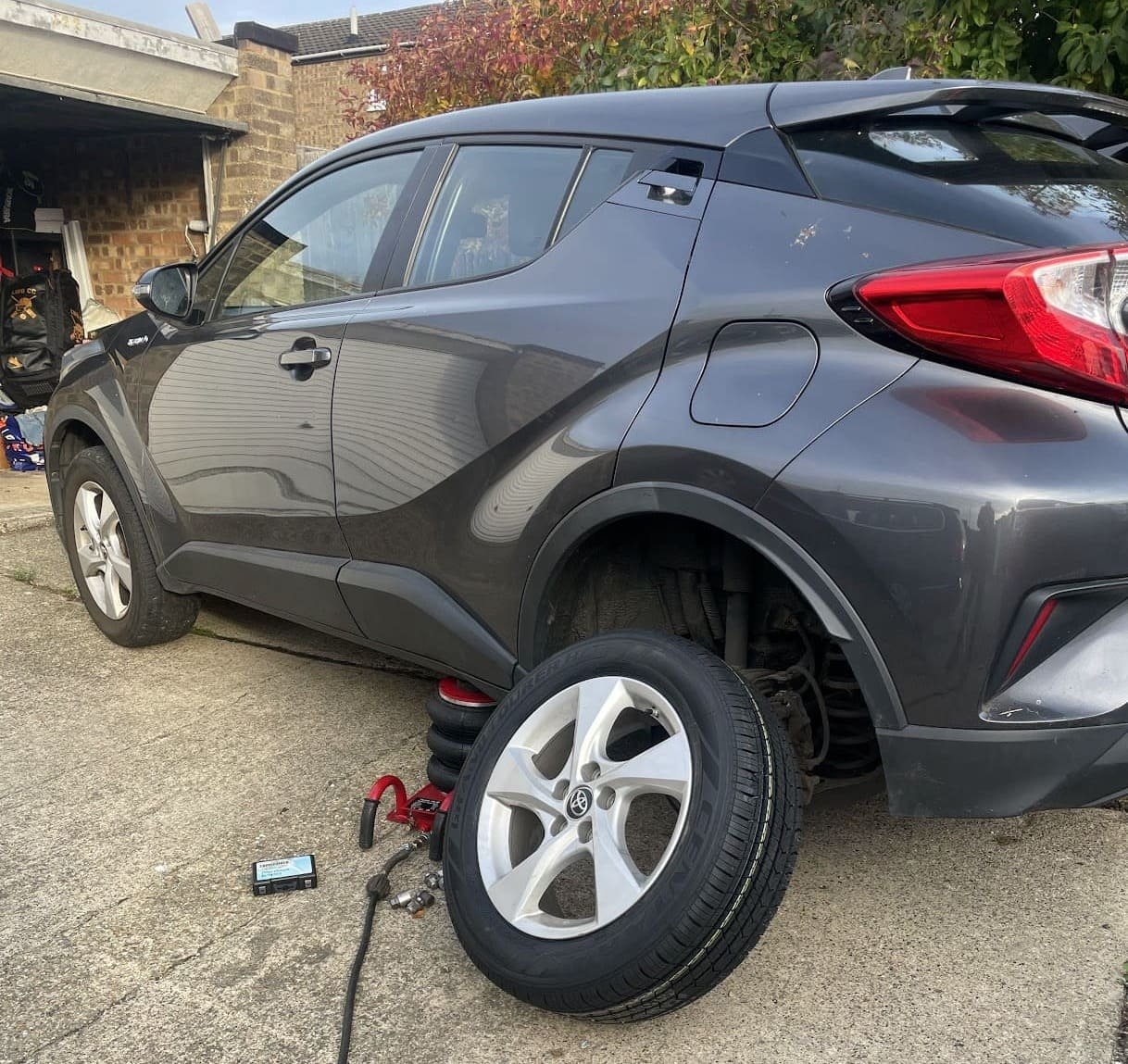 Technician replacing a blown tyre at the roadside at night